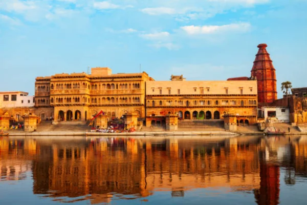 Sunrise over Vrindavan ghats on the Yamuna river with golden light reflecting on water